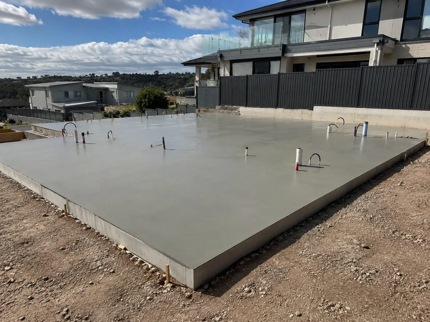 Freshly poured and screeded concrete slab with starter bars protruding, formed up on a Newcastle building site